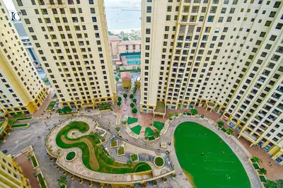 an aerial view of a park in between two tall buildings at Luxury Escapes - Charming 3BR plus maids Apt near JBR Beach - Sadaf 1 in Dubai
