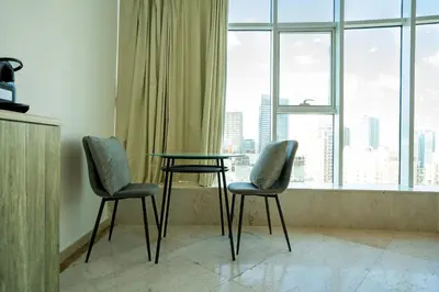 two chairs and a glass table in front of a window at CitiHome - Prime Stylish Studio in Sports City in Dubai