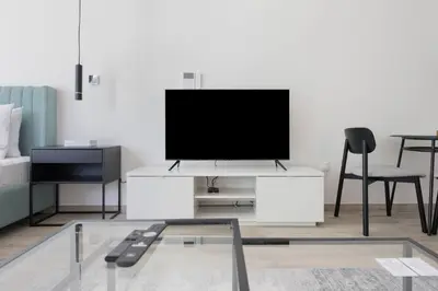 a living room with a flat screen tv on a white cabinet at Ahad Residences Studio- 15mins walk to Dubai Mall in Dubai