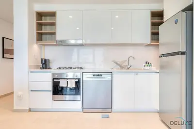 a kitchen with white cabinets and a stainless steel oven at Exquisite 1BR at Downtown Views II Tower 2 Downtown Dubai by Deluxe Holiday Homes in Dubai