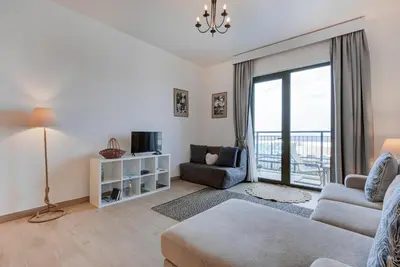 a living room with a couch and a tv at Trophy - Serene Abode near the Coast in Dubai