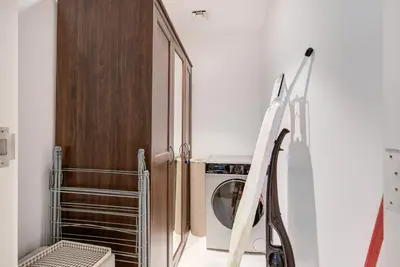 a laundry room with a washing machine and a refrigerator at Trophy - Serene Abode near the Coast in Dubai