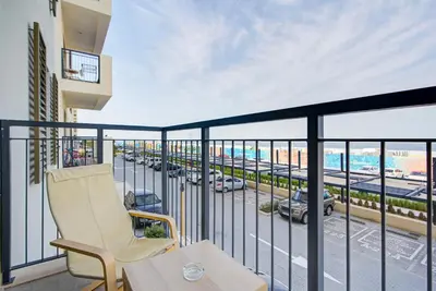 a balcony with a chair and a view of a street at Trophy - Serene Abode near the Coast in Dubai