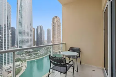 a balcony with a table and chairs and a view of a city at StoneTree - Cozy Studio - JLT in Dubai