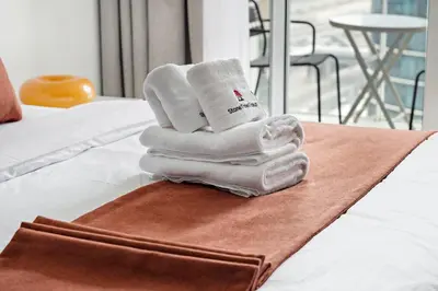 a pile of towels sitting on top of a bed at StoneTree - Cozy Studio - JLT in Dubai