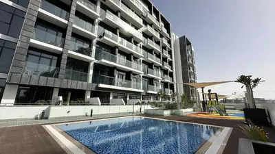 a building with a swimming pool in front of a building at EasyGo - Azizi Riviera 9 Bright Studio in Dubai