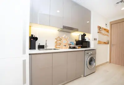 a kitchen with a sink and a washing machine at EasyGo - Azizi Riviera 9 Bright Studio in Dubai