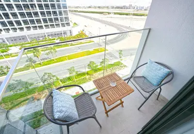 a balcony with a table and chairs and a view of a street at EasyGo - Azizi Riviera 9 Bright Studio in Dubai