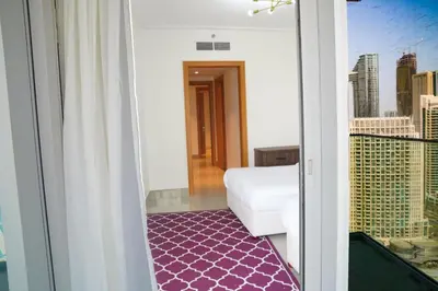 a room with a balcony with a view of a city at Magnificent 3BR with Incredible Burj & Fountain View in Dubai