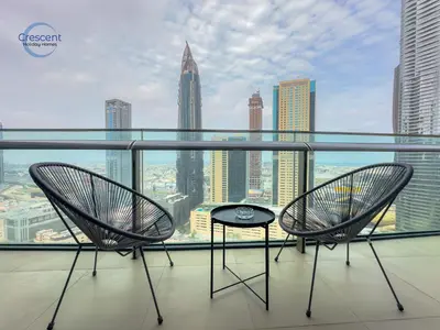 two chairs and a table on a balcony with a city at Burj Vista Burj Khalifa Metro & Mall Access in Dubai