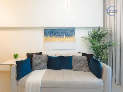 a white couch with blue pillows in a living room at Burj Vista Burj Khalifa Metro & Mall Access in Dubai