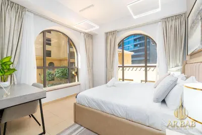 a bedroom with a bed and a desk and windows at Bahar - Luxury 1BR - Near JBR Beach - Prime Location - JBR in Dubai