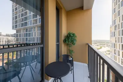 a balcony with a table and chairs on a balcony at Fresh & Quiet 1BR at Midtown Noor 4 Tower in Dubai