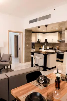 a kitchen and living room with a couch and a table at Dubaistay Luxury 2 Bedroom holiday appartment JVC KING and QUEENSIZE in Dubai