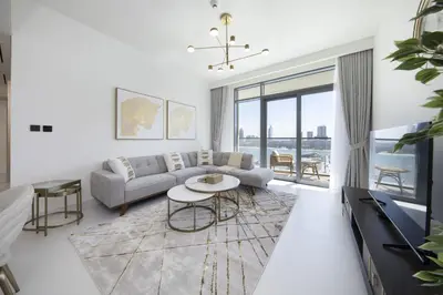 a living room with a couch and a table at 2BR Emaar Beachfront with Full Sea & Skyline Views in Dubai