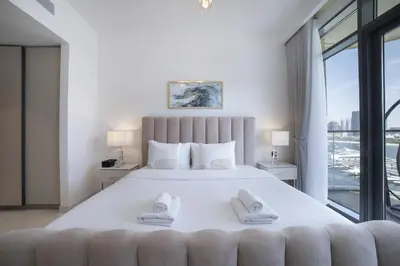 a bedroom with a large white bed with a large window at 2BR Emaar Beachfront with Full Sea & Skyline Views in Dubai