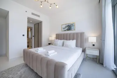 a bedroom with a large white bed with two books on it at 2BR Emaar Beachfront with Full Sea & Skyline Views in Dubai