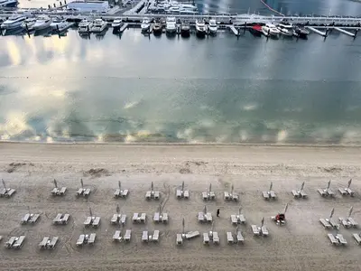 an aerial view of a beach with chairs and boats at 2BR Emaar Beachfront with Full Sea & Skyline Views in Dubai