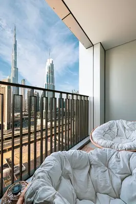 a bedroom with a balcony with a view of a city at Burj Khalifa View, High Floor, Dubai Mall Access, Gym, Infinity-Pool, Playground, BBQ, Family Friendly in Dubai