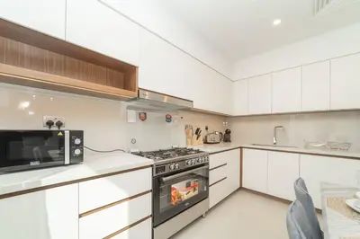 a kitchen with a stove and a microwave at Luxurious 3 BR with Maid Room in Arabian Ranches 2 in Dubai
