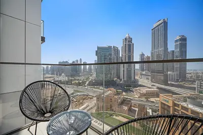 a balcony with two chairs and a view of a city at Silkhaus Comfy 1BR by Burj Khalifa with Balcony in Dubai