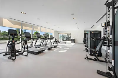 a gym with rows of treadmills and ellipticals at Silkhaus Comfy 1BR by Burj Khalifa with Balcony in Dubai