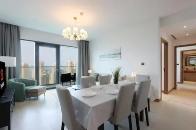 a dining room with a white table and chairs at Livbnb - Modern 3BR with Marina & Sunset View in Dubai