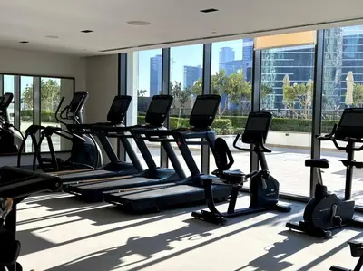 a row of treadmills in a gym with windows at Burj Crown - Luxury Apartment Near Burj Khalifa in Dubai