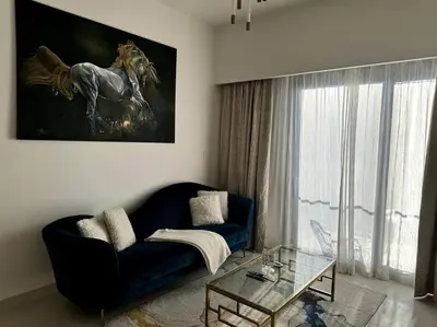 a living room with a blue couch and a horse painting at Burj Crown - Luxury Apartment Near Burj Khalifa in Dubai