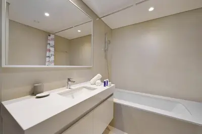 a bathroom with a sink and a mirror at Maison Privee - Modern Chic Apt with Unobstructed Burj Khalifa Views in Dubai