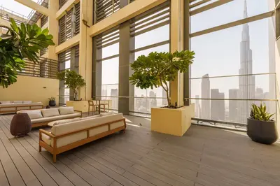 a large room with large windows and potted plants at Maison Privee - Modern Chic Apt with Unobstructed Burj Khalifa Views in Dubai