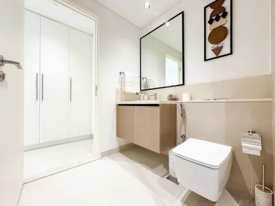 a bathroom with a toilet and a sink and a mirror at First Class Stay in Downtown Dubai Near Burj Park by SBH in Dubai