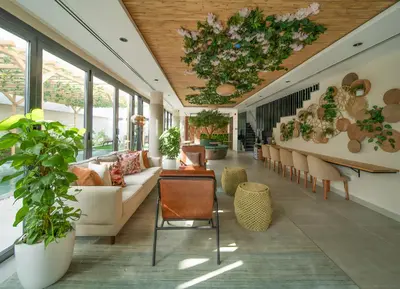 a lobby with a couch and chairs and plants at Nas House Private & Shared Villas in Dubai
