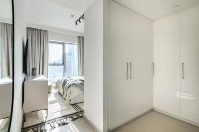 a bedroom with white cabinets and a bed at The Smart Concierge - Downtown views 2 in Dubai