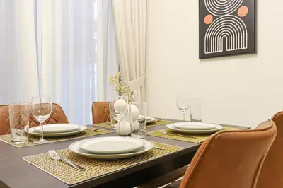 a dining room table with plates and wine glasses at HiGuests - Tranquil Luxury 1BR Apt in the Heart of the City in Dubai