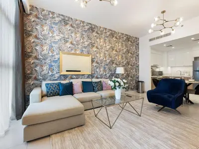 a living room with a couch and a table at Modern Comforts -1 BR in Park Point- Dubai Hills in Dubai