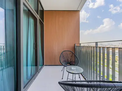 a balcony with a table and chairs on a building at Modern Comforts -1 BR in Park Point- Dubai Hills in Dubai