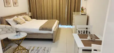 a bedroom with a bed and a table and a couch at Carson Tower C - Damac Hills by Golden Casa in Dubai