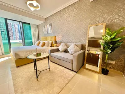 a bedroom with a bed and a couch and a table at Cosmos Living Cozy Studio GCV2 in Dubai
