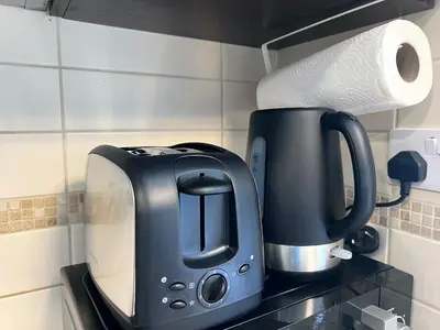 a black toaster and a roll of paper towels at Cosmos Living Cozy Studio GCV2 in Dubai