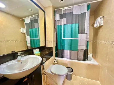 a bathroom with a sink and a toilet and a shower at Cosmos Living Cozy Studio GCV2 in Dubai
