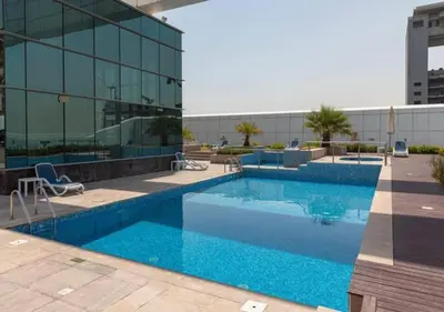 a large swimming pool in front of a building at Cosmos Living Cozy Studio GCV2 in Dubai
