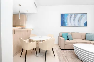 a living room with a table and chairs and a couch at The Seven Palm in Dubai