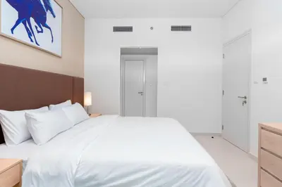 a bedroom with a large white bed with white pillows at The Seven Palm in Dubai