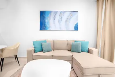 a living room with a couch and a painting on the wall at The Seven Palm in Dubai