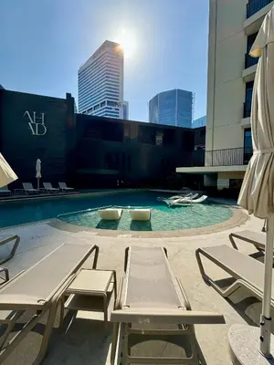 a pool with chairs and umbrellas on a building at Capsule Flora business bay view Burj Khalifa-pool table-game arcade-Projector-Playstation 5 in Dubai