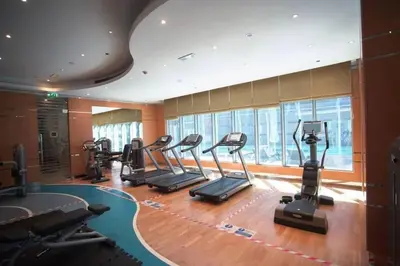 a gym with treadmills and ellipticals in a room at LUX 1 bed flat with Burj Khalifa View - 3 minute walk to Dubai Mall - Best Location - Best Balcony View in Dubai