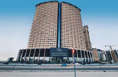 a large building with a sign in front of it at Binghatti avenue in Dubai