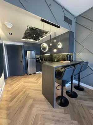 a kitchen with a counter and a bar with stools at Binghatti avenue in Dubai