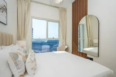 a bedroom with a white bed and a mirror at Homesgetaway Luxury 2BR at Socio Dubai hills in Dubai